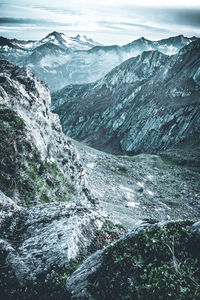 Scenic view of snow covered mountain against cloudy sky