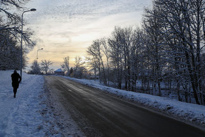 Rear view of person on snow covered road