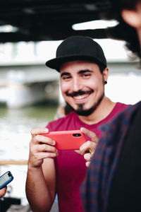 Portrait of smiling young man holding hat