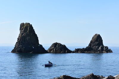 Scenic view of rock formation in sea against sky