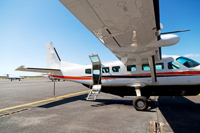 Airplane on airport runway against clear blue sky