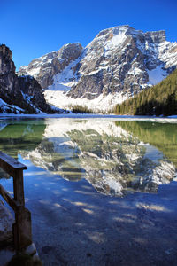 Scenic view of lake by snowcapped mountains against sky