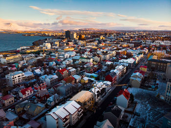 High angle view of townscape by sea against sky