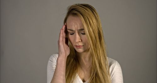 Portrait of beautiful young woman against wall