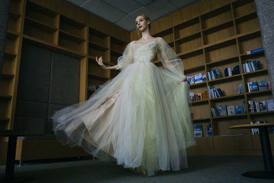 A charming ballerina went to the library to choose new book showing your stretching and flexibility