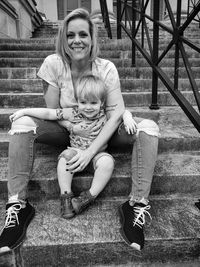 Portrait of young woman sitting on staircase