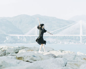 Full length of woman on beach against clear sky