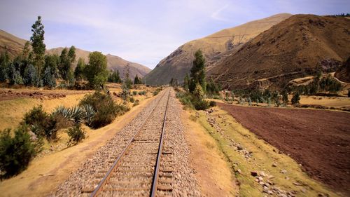 Road leading towards mountains against sky