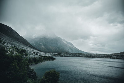 Scenic view of lake by mountains against sky