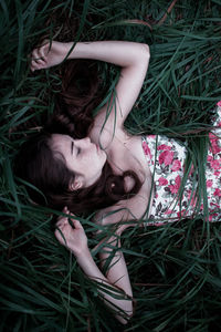 High angle portrait of young woman lying on grass