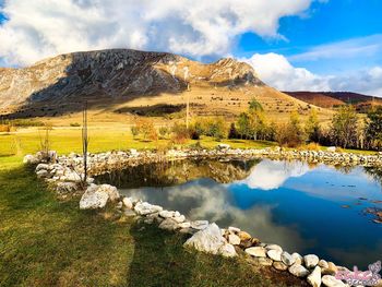Scenic view of lake and mountains against sky