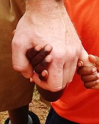 Close-up of father holding hands