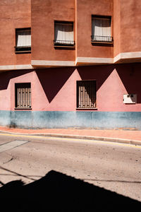 Empty road by buildings in city