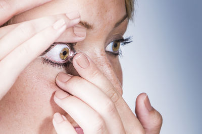 Close-up of woman applying contact lens