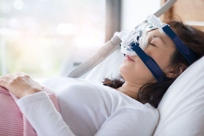 Close-up of woman on bed in hospital