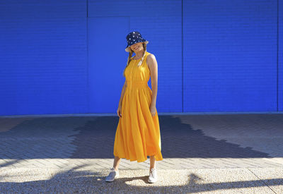 Woman standing against blue wall