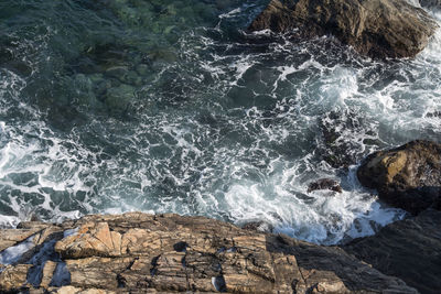 High angle view of waves breaking on rocks