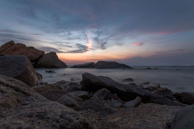 Rocks on beach against sky during sunset at minyak beku, malaysia.