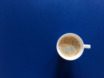 Directly above shot of coffee on table against blue background