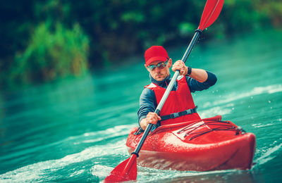 Man with red umbrella on boat