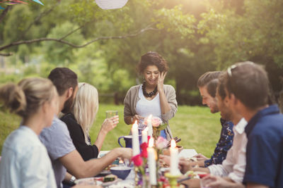 Smiling woman with friends at table in garden party