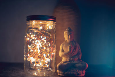 Close-up of illuminated statue on table