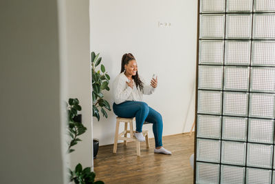 Side view of woman sitting on wall