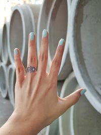 Cropped hand of woman showing painted fingernails