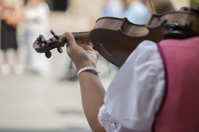 Midsection of man playing violin at music concert