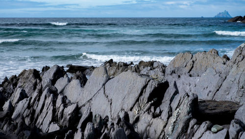 Scenic view of rocky beach against sky