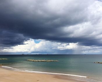 Scenic view of sea against storm clouds