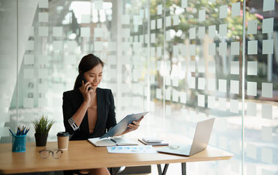 Businesswoman using laptop while sitting on table