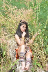 Full length of woman sitting on field