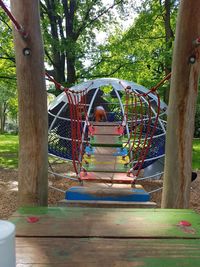 Rear view of kid playing at jungle gym in playground