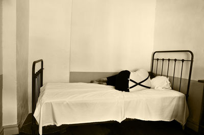 Rear view of man lying on bed at home