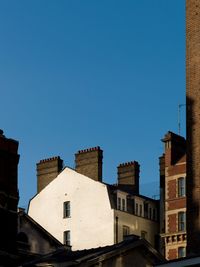 Low angle view of buildings against clear blue sky