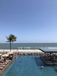 Swimming pool by sea against clear blue sky in bali - indonesia