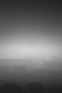 Silhouette of buildings in city against sky