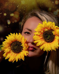 Close-up portrait of woman with yellow flower