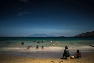 People at beach against sky at night