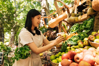 Portrait of young woman picking fruit