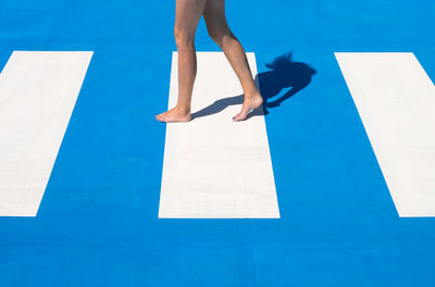 Low section of woman standing on swimming pool