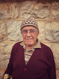 Portrait of smiling man standing against wall