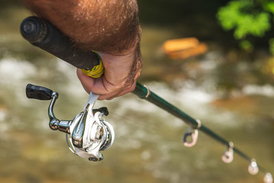 Cropped hand holding fishing rod