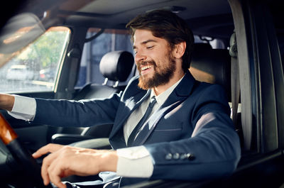 Portrait of businessman using mobile phone while sitting in car