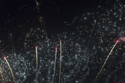 Low angle view of fireworks against sky at night