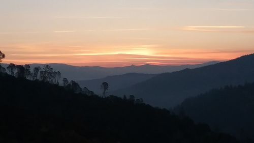 Scenic view of silhouette mountains against sky at sunset