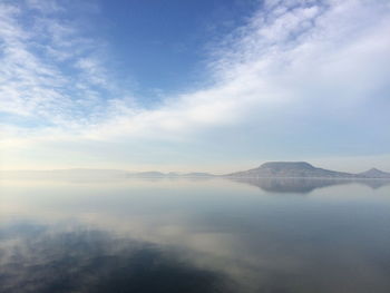 View of calm lake against cloudy sky