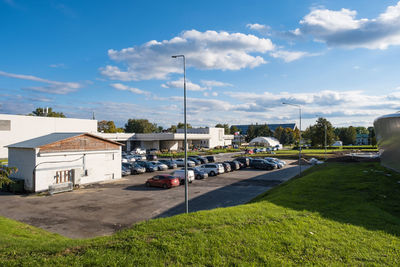 Road by buildings against sky in city