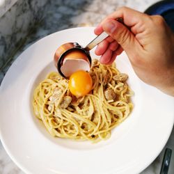 Cropped hand having food from plate